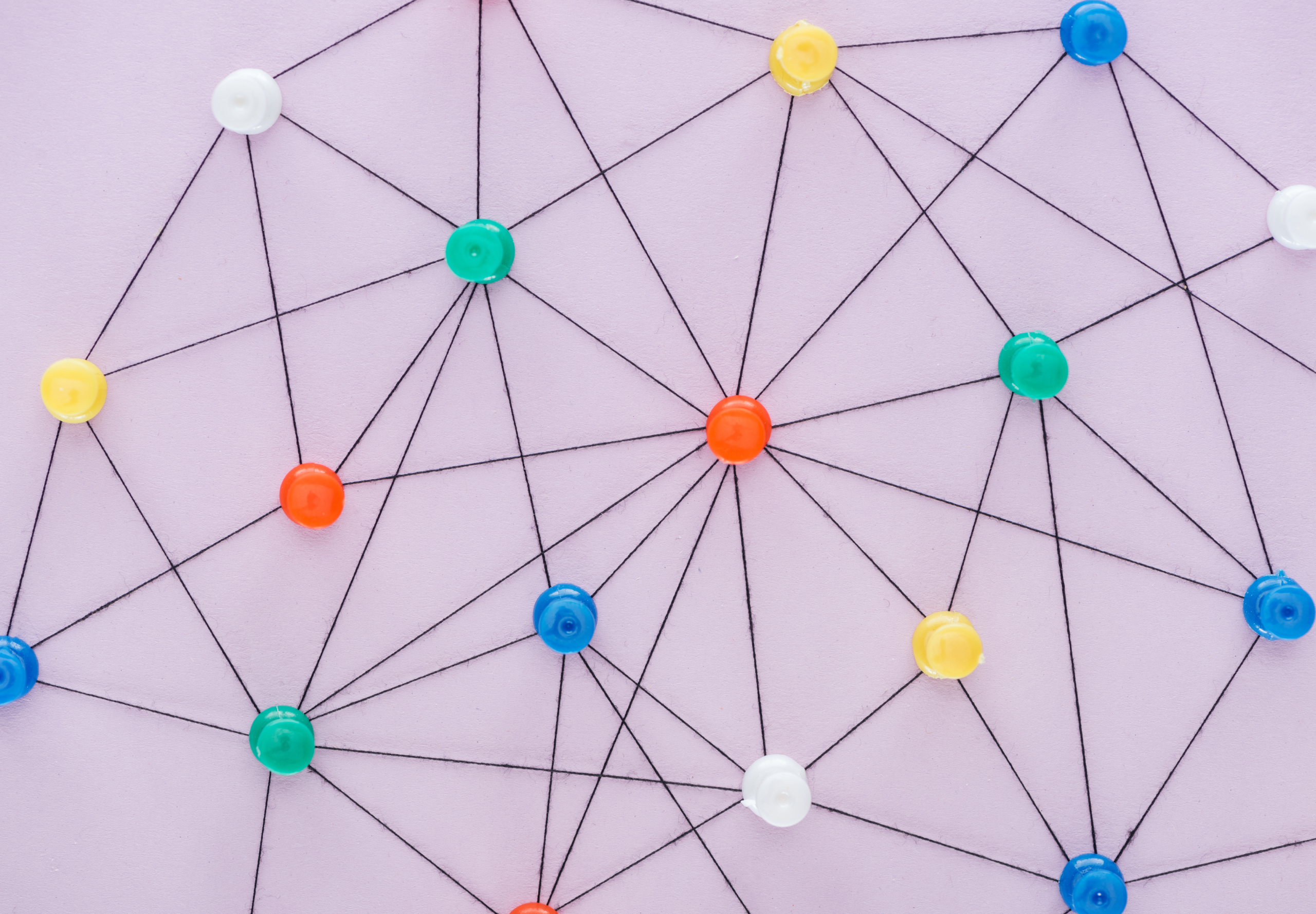 Colourful pushpins connected by string in a network